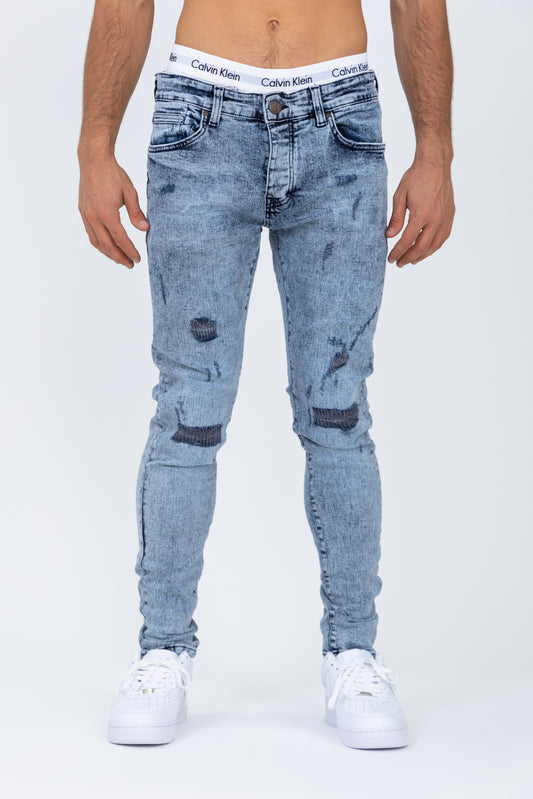 Graue, zerrissene Röhrenjeans
